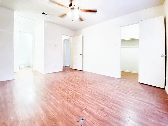 a view of an empty room with wooden floor