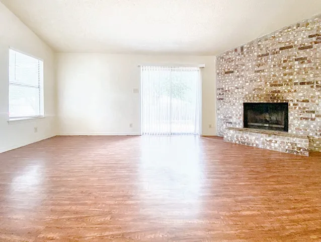 an empty room with wooden floor and fireplace
