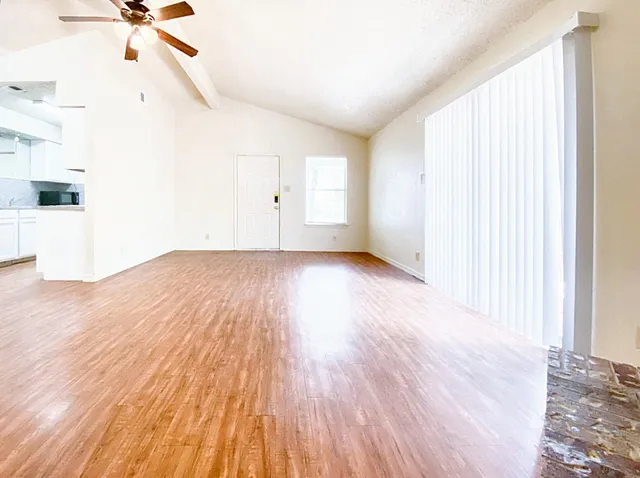 a view of a room with wooden floor and white walls