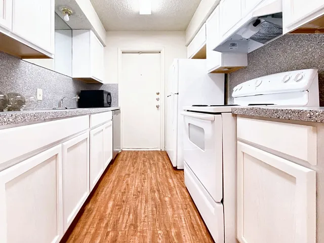 a kitchen with white cabinets and sink