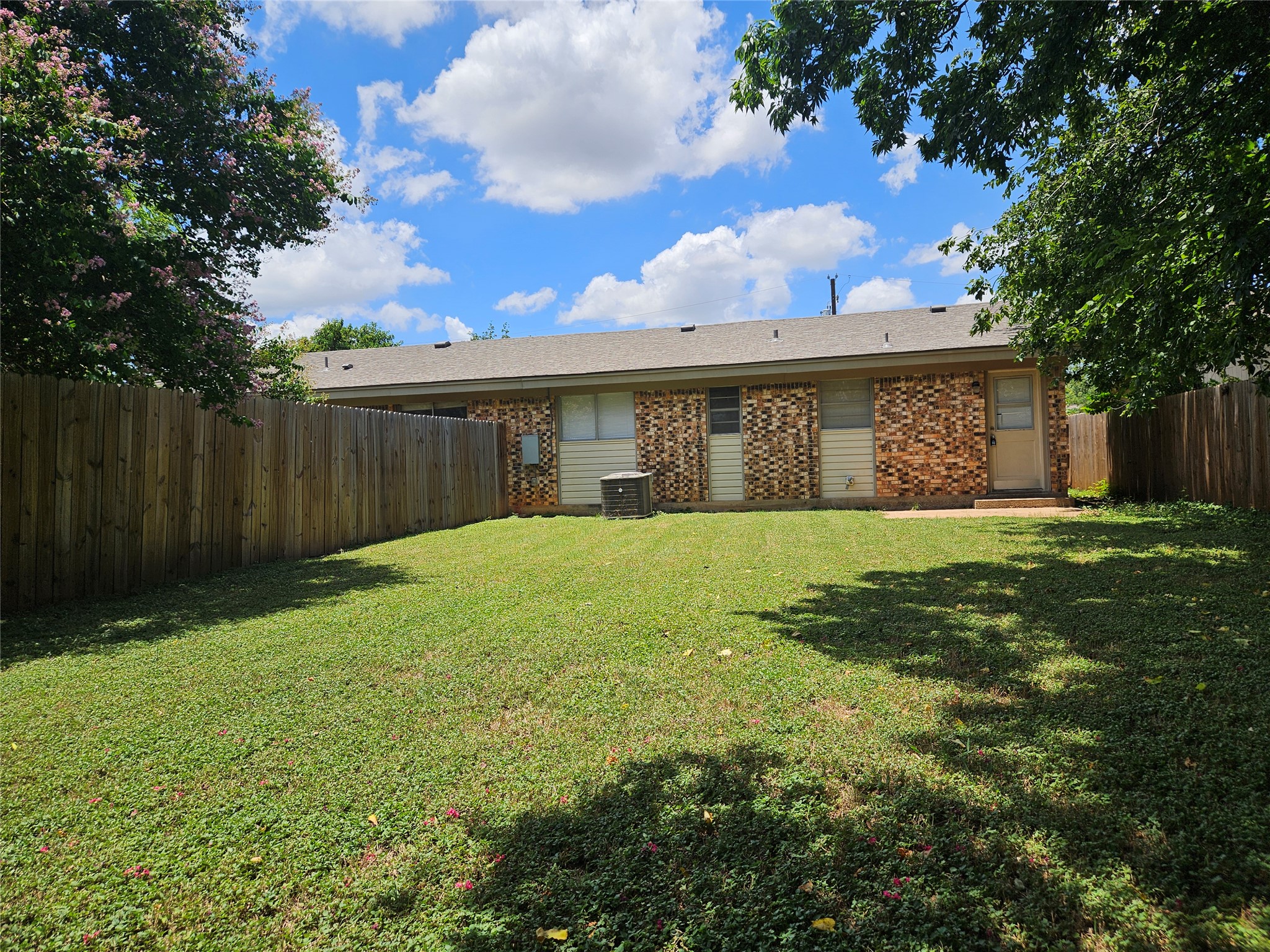 806 Ranch Road, Unit A Georgetown, TX 78628 - Photo 18 of 24 A private, fenced backyard offers a verdant lawn, ideal for outdoor leisure.