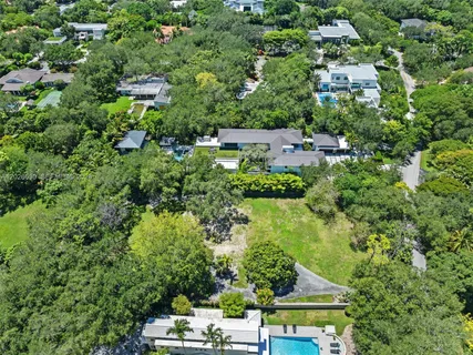 an aerial view of residential house with outdoor space and trees all around