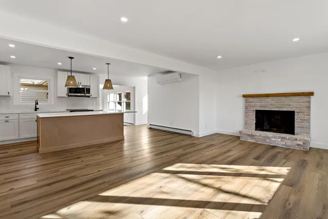 a large kitchen with kitchen island a sink a stove a refrigerator and white cabinets
