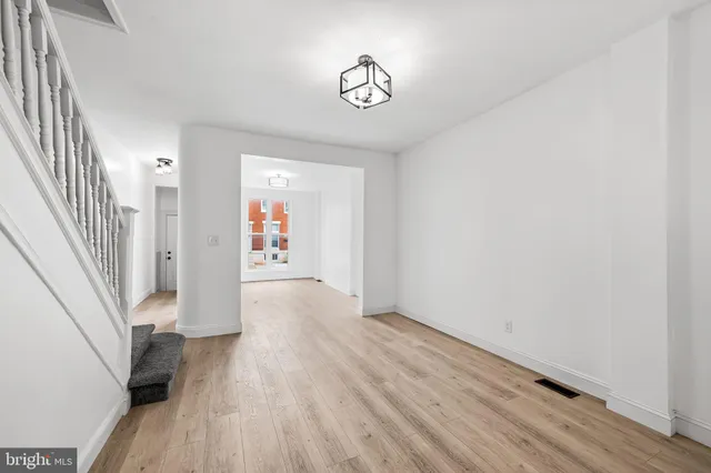 a view of a hallway with wooden floor and staircase