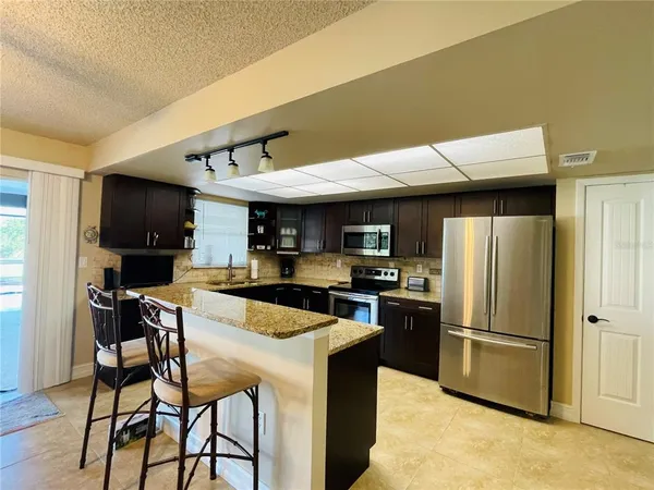 a kitchen with kitchen island a counter space a sink appliances and cabinets