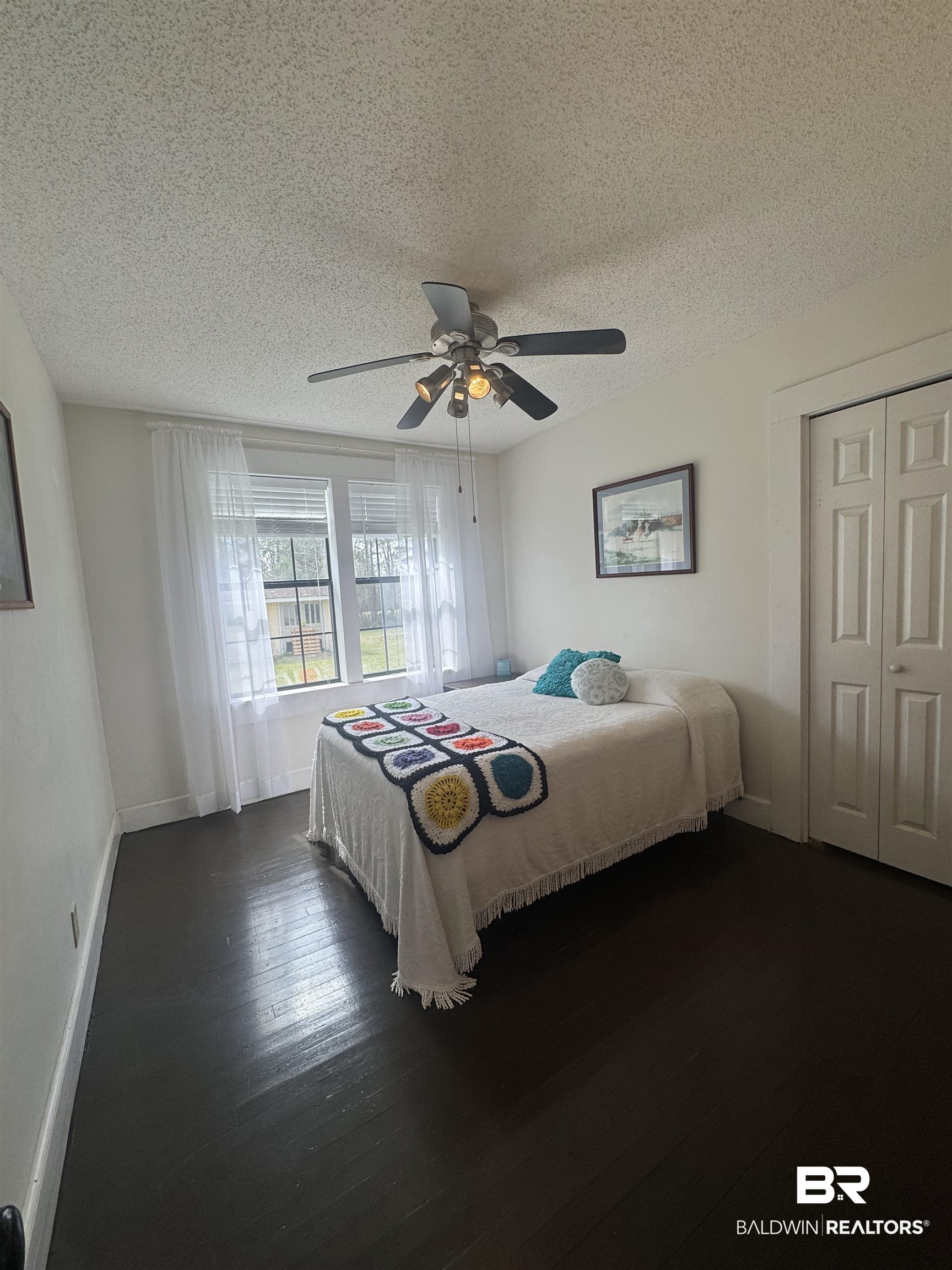 275 Thames Road Frisco City, AL 36445 - Photo 21 of 24 Bedroom with ceiling fan, a textured ceiling, dark wood finished floors, and baseboards