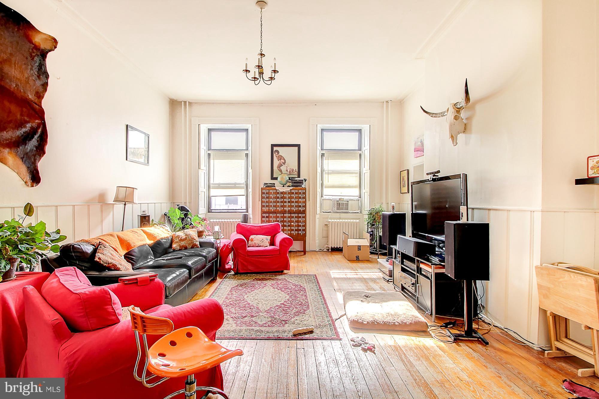 18 West Franklin Street Baltimore, MD 21201 - Photo 14 of 30 a living room with furniture a flat screen tv and a floor to ceiling window