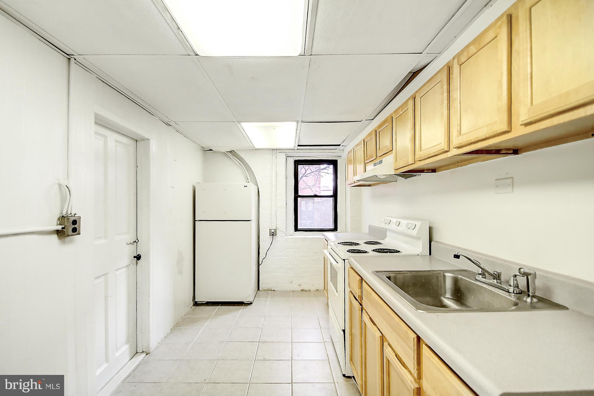 18 West Franklin Street Baltimore, MD 21201 - Photo 29 of 30 a kitchen with a sink a refrigerator and cabinets