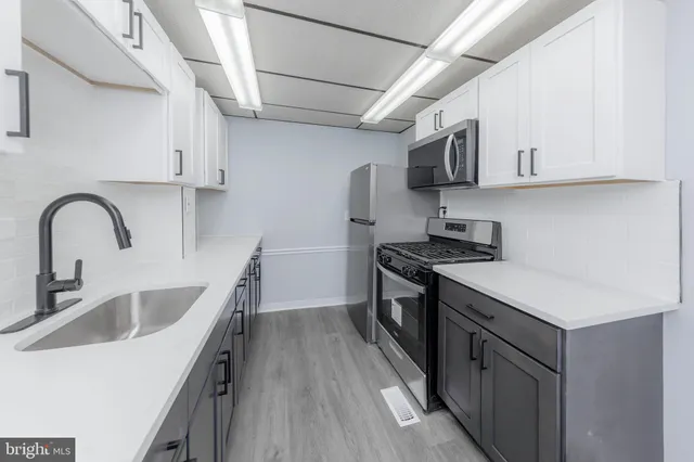 a kitchen with stainless steel appliances granite countertop a sink stove and cabinets