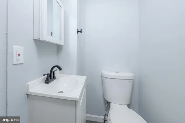 a bathroom with a toilet sink and mirror