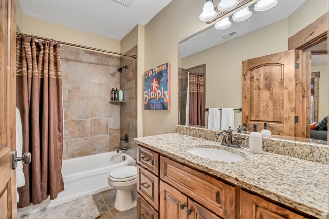 9049 Timphaven Road Sundance, UT 84604 - Photo 53 of 63 Ensuite bathroom with vanity, a textured ceiling, shower / bath combination with curtain, and light tile patterned floors