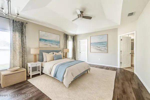 a spacious bedroom with a large bed and a chandelier