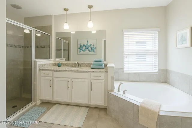 a bathroom with a granite countertop sink a bathtub a shower and a mirror