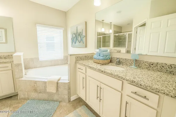 a bathroom with a granite countertop sink and a bathtub