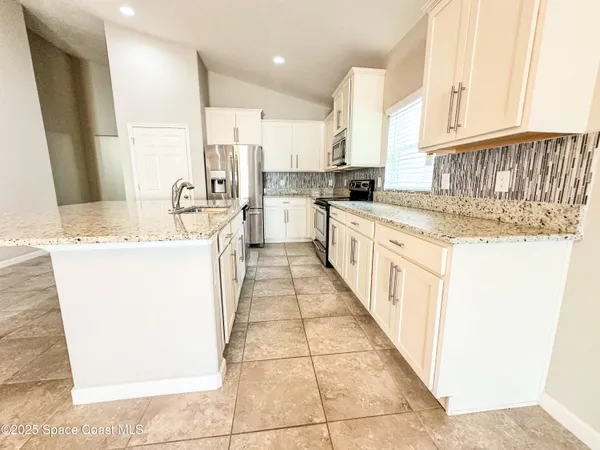 a kitchen with stainless steel appliances granite countertop a sink and cabinets