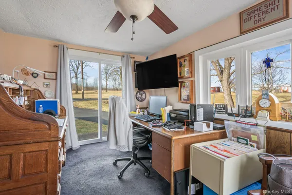 a bedroom with furniture a flat screen tv and a window
