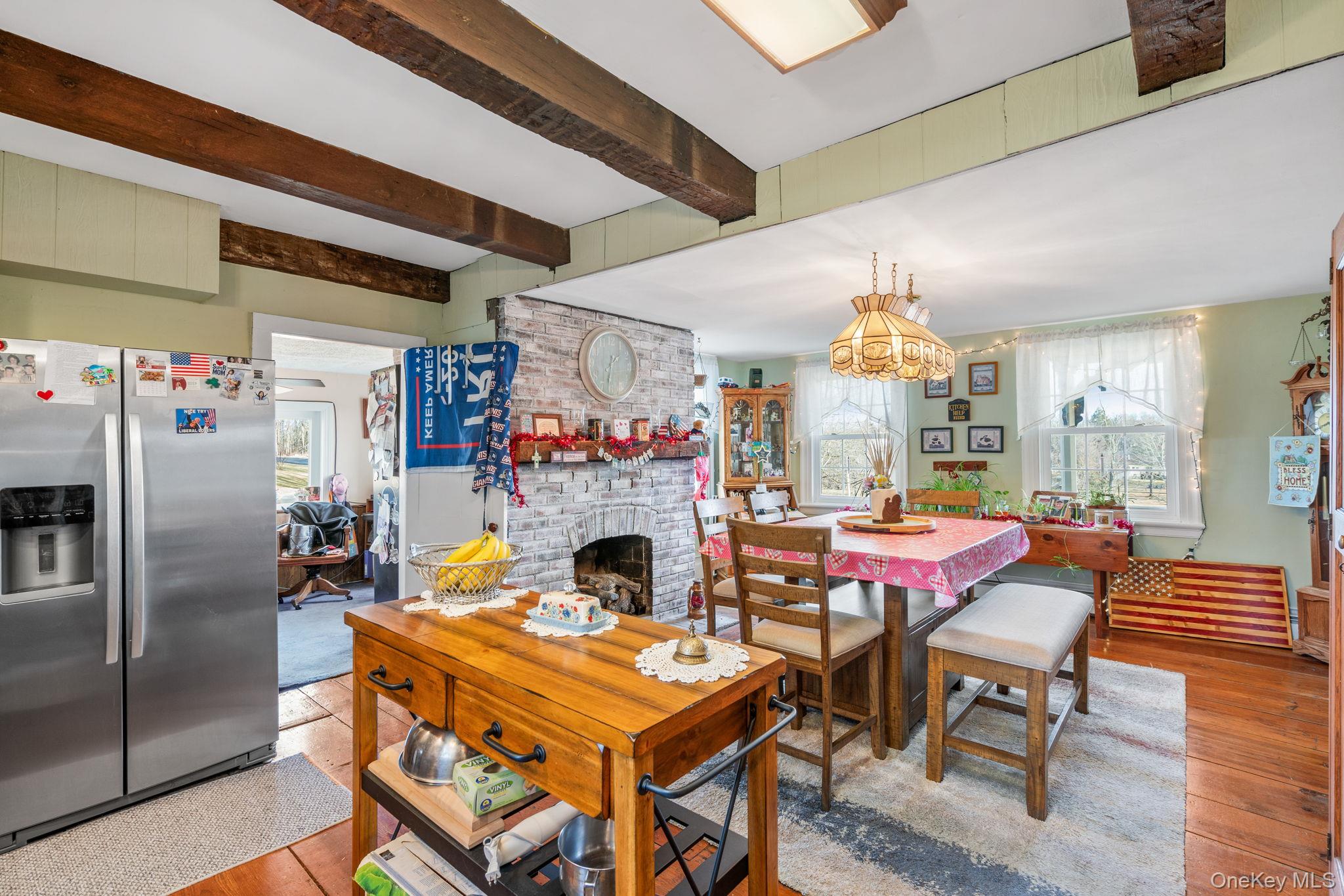 69 Lippincott Road Wallkill, NY 12589 - Photo 7 of 34 Dining room with beam ceiling, an inviting chandelier, light hardwood / wood-style floors, and a brick fireplace