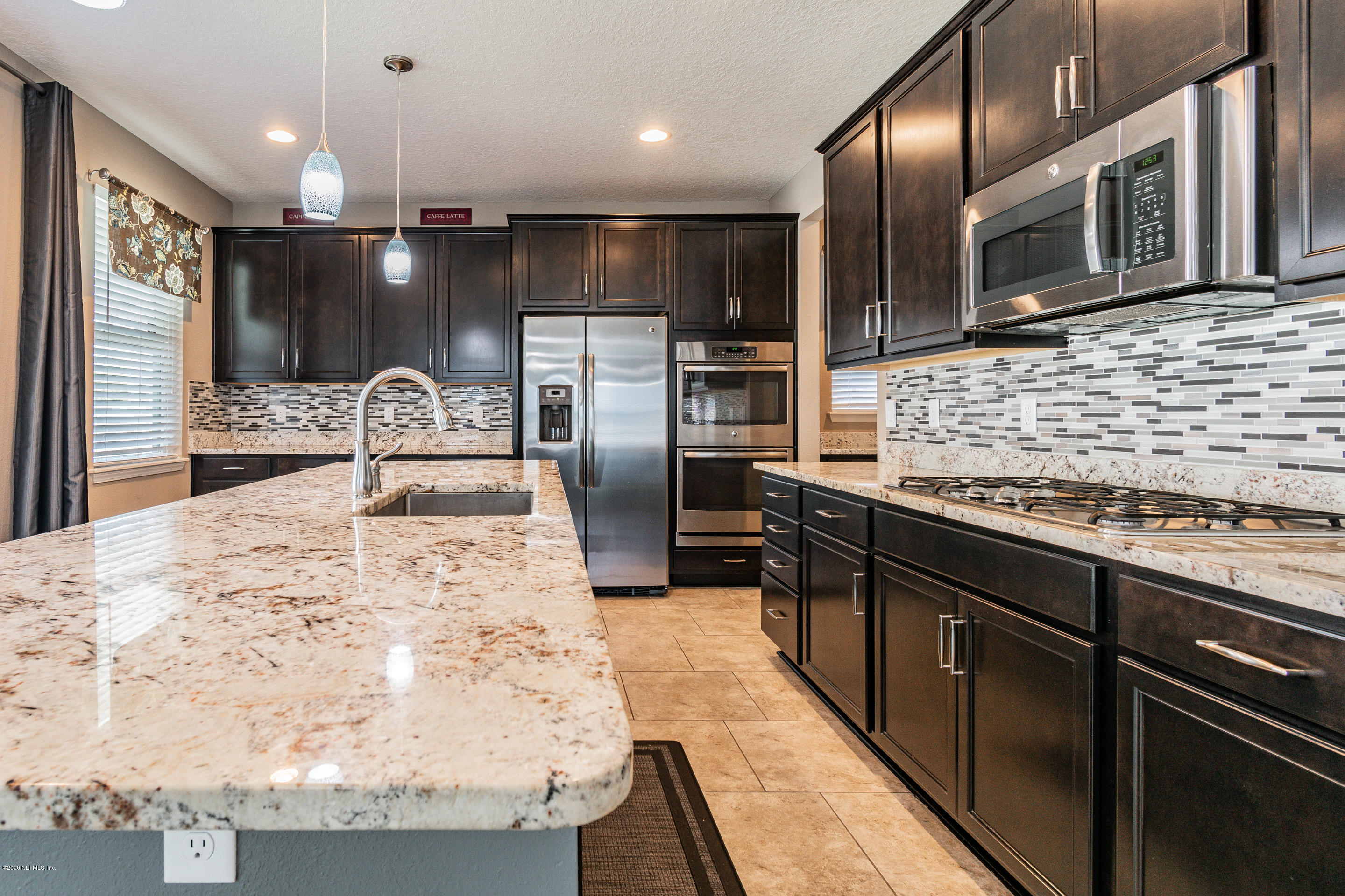 6737 Discovery Crossing Road Jacksonville, FL 32259 - Photo 11 of 51 a kitchen with stainless steel appliances kitchen island granite countertop a refrigerator a stove and a sink