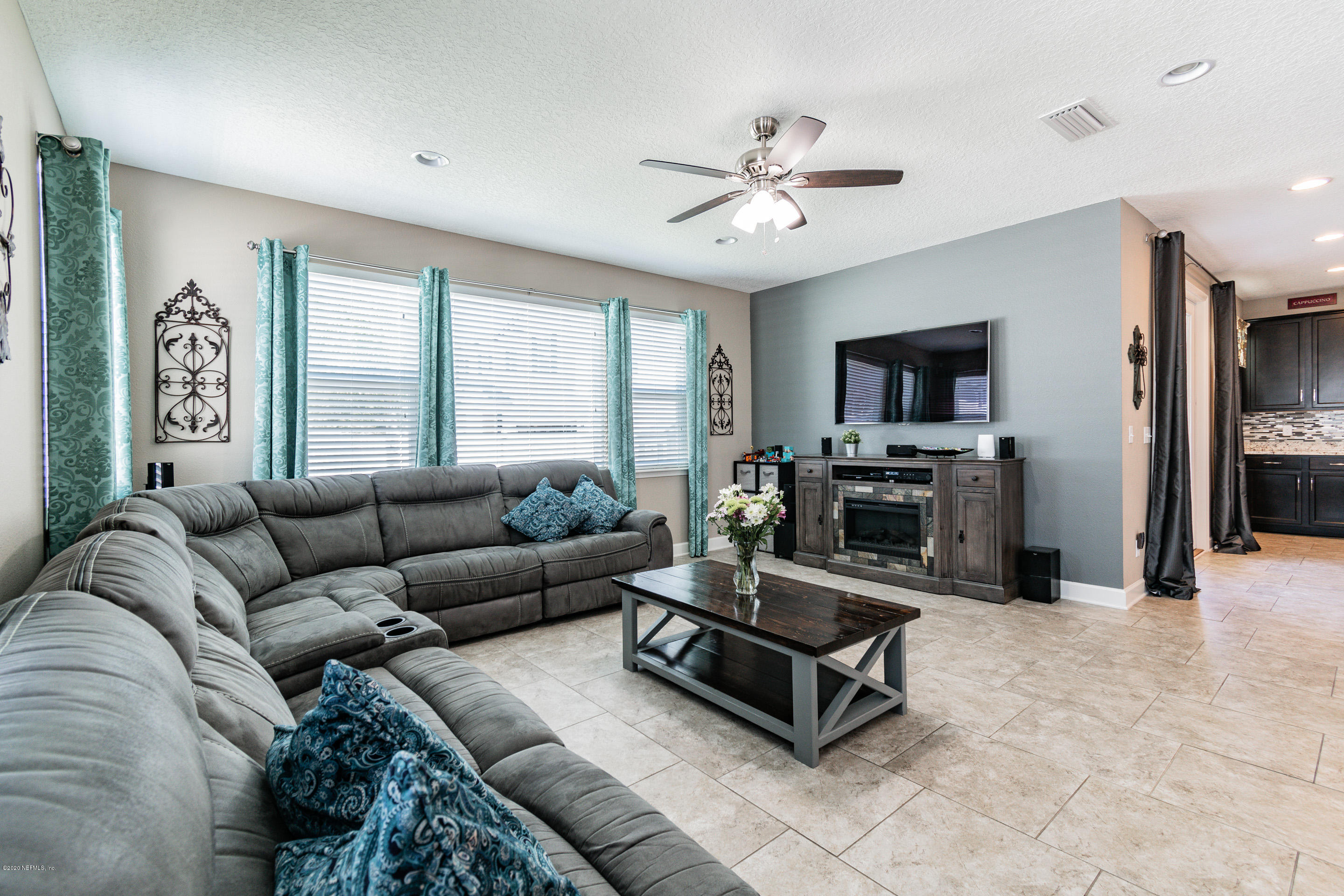 6737 Discovery Crossing Road Jacksonville, FL 32259 - Photo 23 of 51 a living room with furniture a flat screen tv and a fireplace
