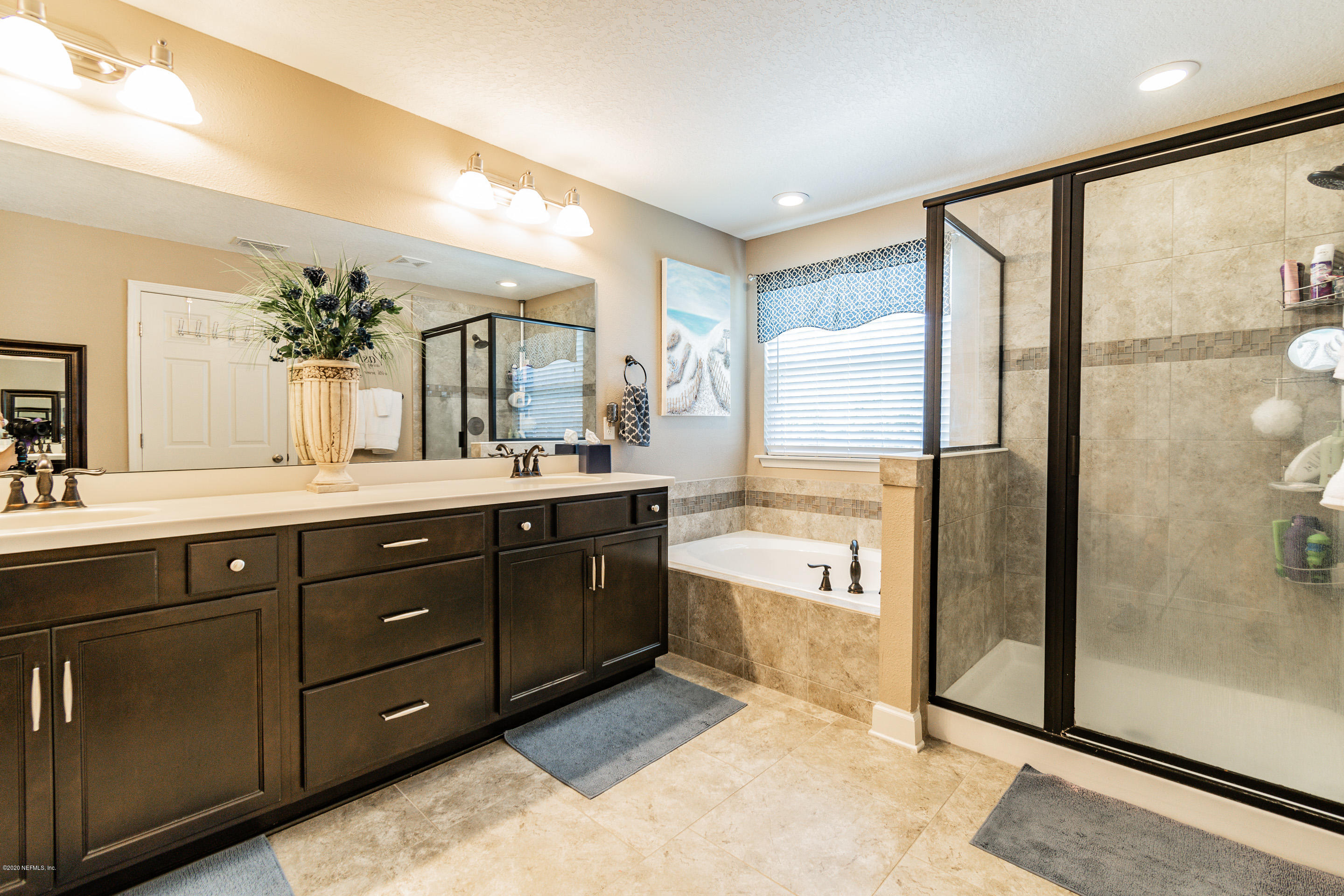 6737 Discovery Crossing Road Jacksonville, FL 32259 - Photo 43 of 51 a spacious bathroom with a granite countertop sink mirror and a bathtub