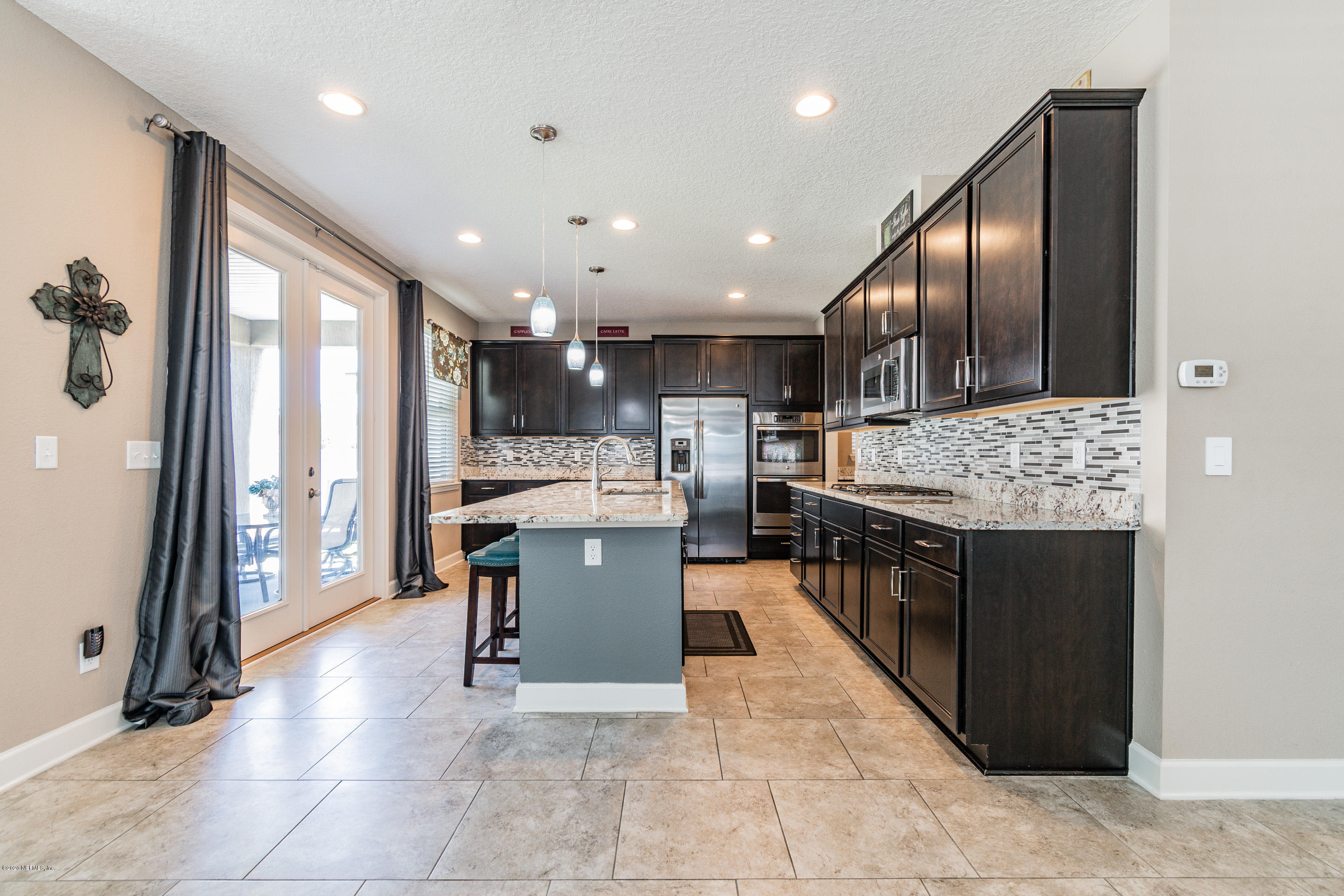 6737 Discovery Crossing Road Jacksonville, FL 32259 - Photo 6 of 51 a open kitchen with stainless steel appliances kitchen island granite countertop a refrigerator and stove top oven with a dishwasher
