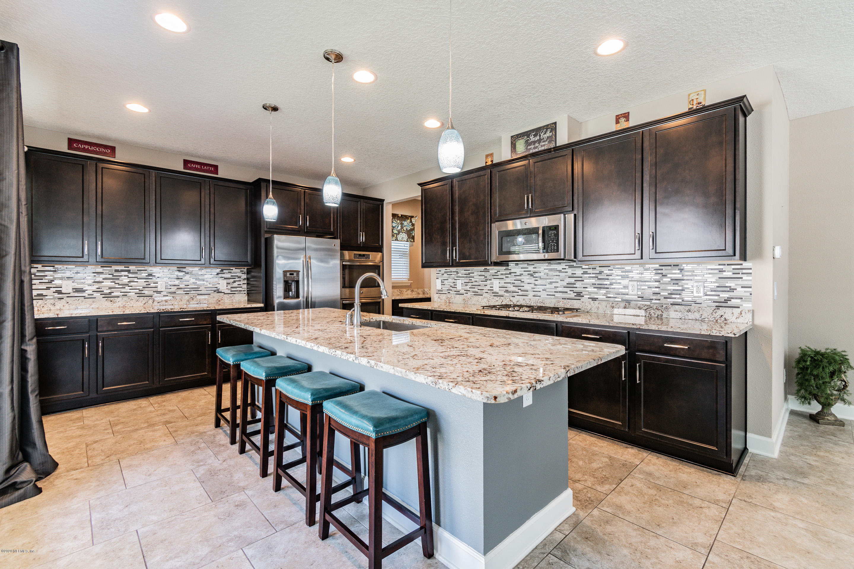 6737 Discovery Crossing Road Jacksonville, FL 32259 - Photo 8 of 51 a kitchen with kitchen island granite countertop wooden cabinets and stainless steel appliances