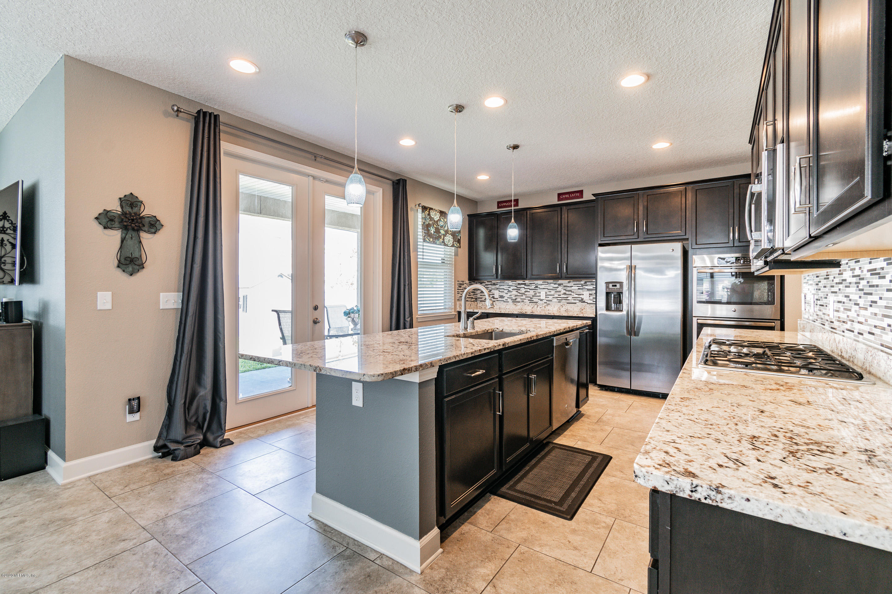 6737 Discovery Crossing Road Jacksonville, FL 32259 - Photo 9 of 51 a large kitchen with stainless steel appliances kitchen island granite countertop a large counter top and wooden floors