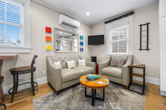 a living room with furniture a flat screen tv and a window
