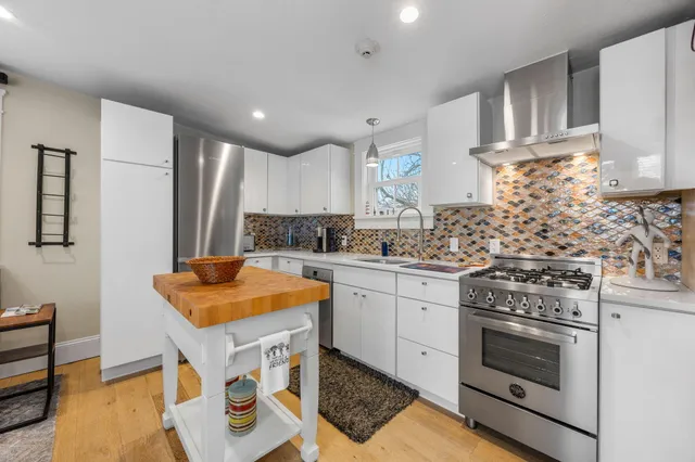 a kitchen with stainless steel appliances granite countertop a stove a sink and a refrigerator