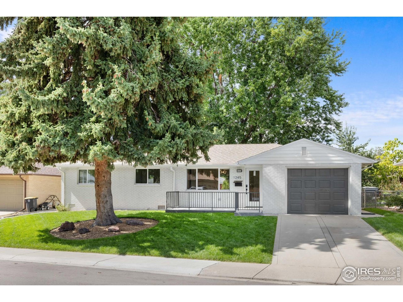 1245 Sumner Street Longmont, CO 80501 - Photo 1 of 25 a front view of a house with garden