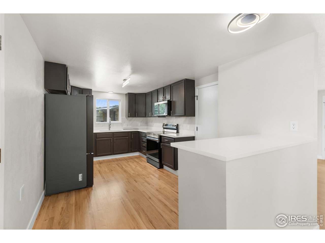 1245 Sumner Street Longmont, CO 80501 - Photo 13 of 25 a kitchen with stainless steel appliances a refrigerator sink and microwave