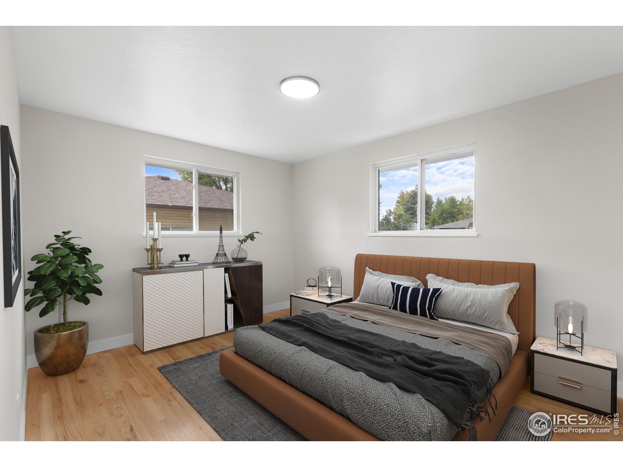 1245 Sumner Street Longmont, CO 80501 - Photo 16 of 25 a bedroom with a bed and a potted plant