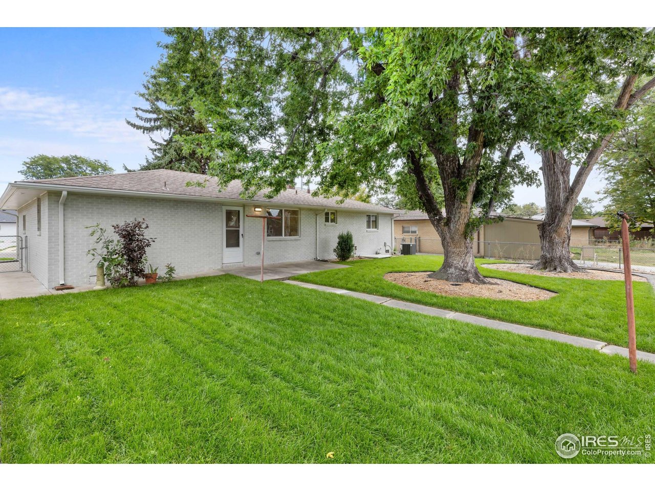 1245 Sumner Street Longmont, CO 80501 - Photo 20 of 25 a front view of a house with garden