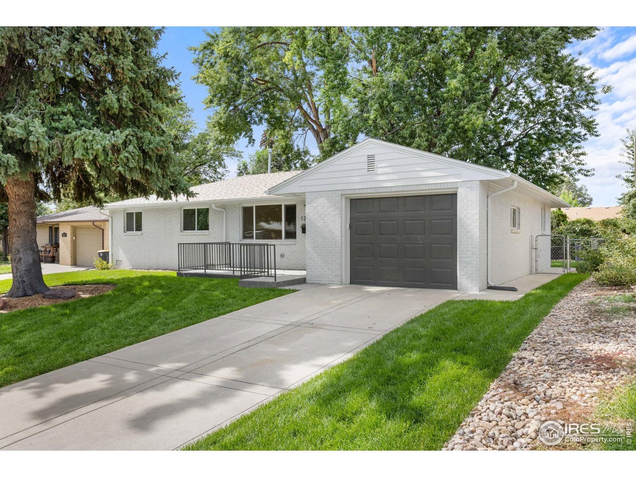 1245 Sumner Street Longmont, CO 80501 - Photo 3 of 25 a front view of a house with a yard and garage