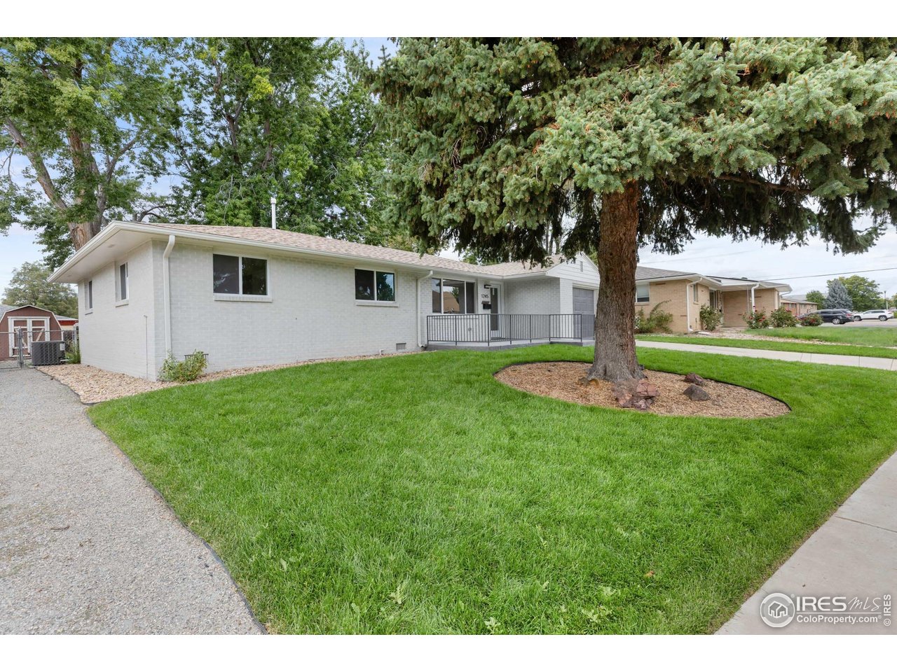 1245 Sumner Street Longmont, CO 80501 - Photo 4 of 25 a front view of a house with a garden