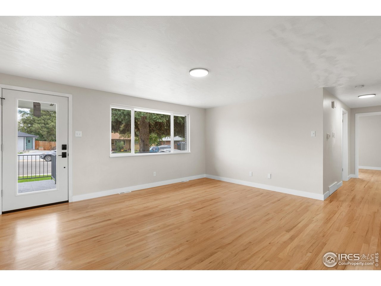 1245 Sumner Street Longmont, CO 80501 - Photo 5 of 25 an empty room with wooden floor and windows