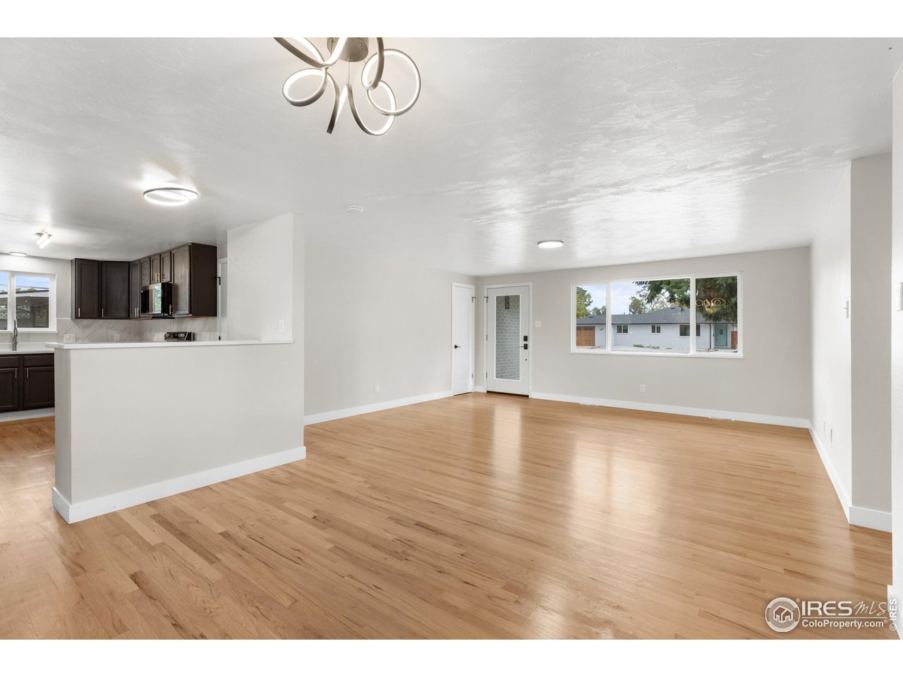 1245 Sumner Street Longmont, CO 80501 - Photo 6 of 25 a view of an empty room with window and wooden floor