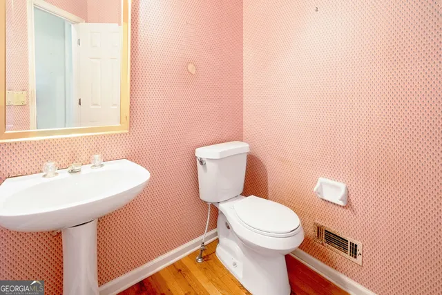 a bathroom with a toilet a sink and mirror