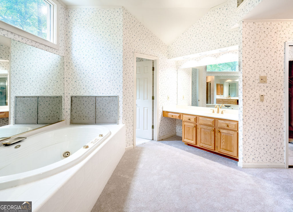 115 Monte Ridge Way Fayetteville, GA 30215 - Photo 18 of 32 a bathroom with a tub a sink and a large mirror