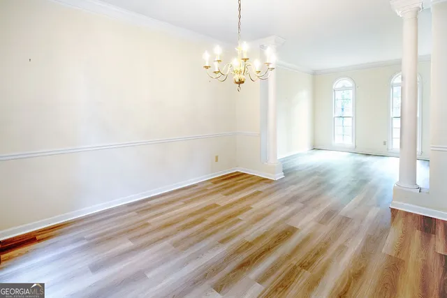 a view of a room with wooden floor and chandelier