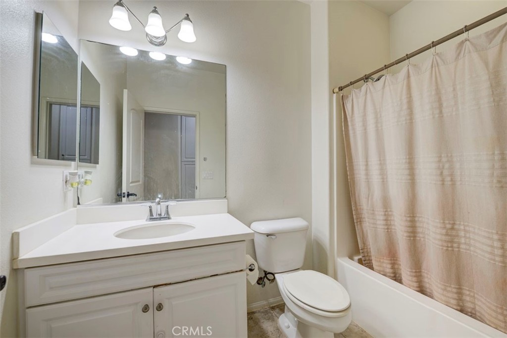 2071 Atlantic Avenue Long Beach, CA 90806 - Photo 11 of 15 a bathroom with a sink a toilet a mirror and shower curtain