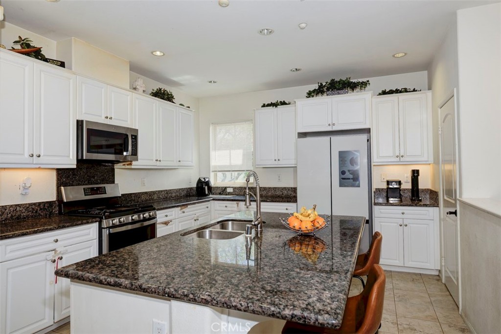 2071 Atlantic Avenue Long Beach, CA 90806 - Photo 7 of 15 a kitchen with stainless steel appliances granite countertop a sink stove and refrigerator