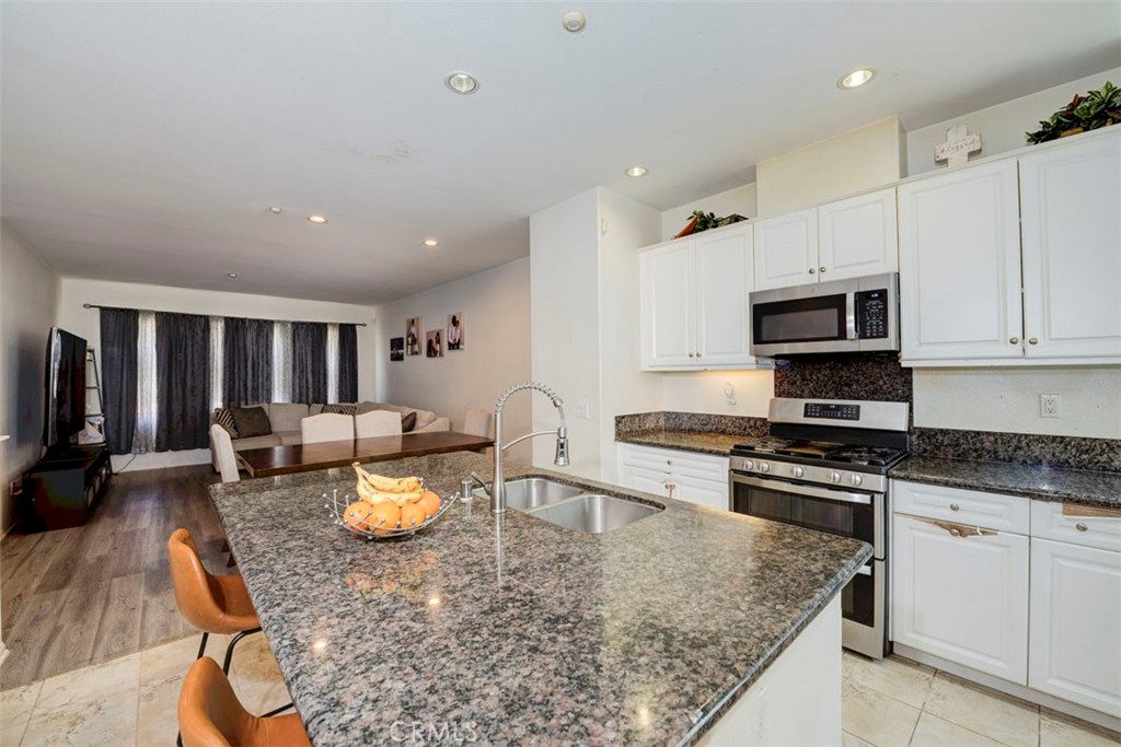 2071 Atlantic Avenue Long Beach, CA 90806 - Photo 15 of 15 a kitchen with a stove a sink a kitchen island with a dining table and chairs
