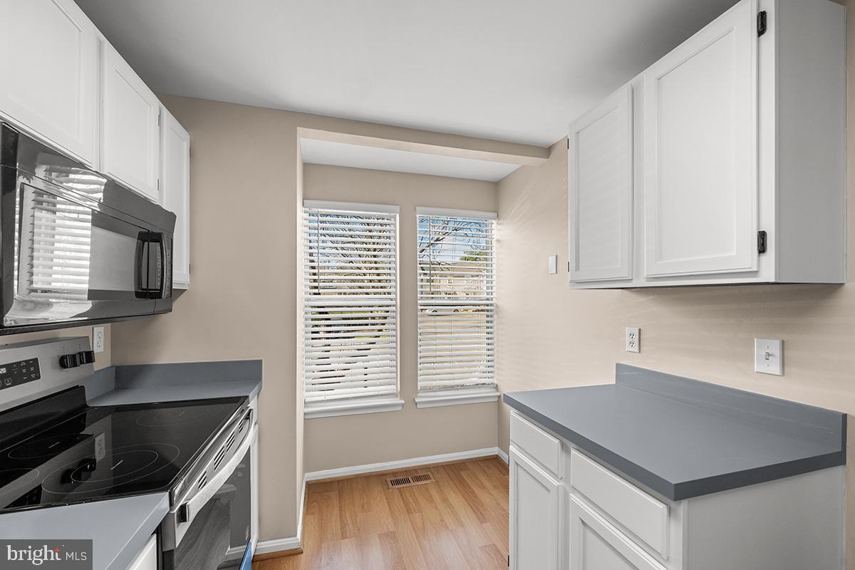 144 Forests Edge Place Laurel, MD 20724 - Photo 3 of 31 a kitchen with granite countertop a stove a sink and a microwave