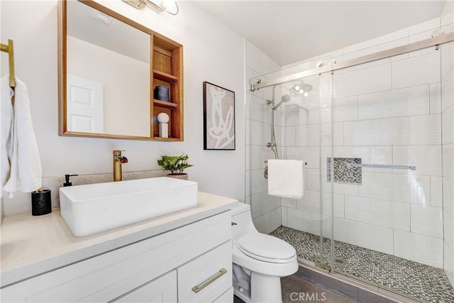 a bathroom with a sink a toilet and shower