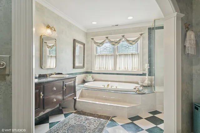 a bathroom with a tub sink and mirror