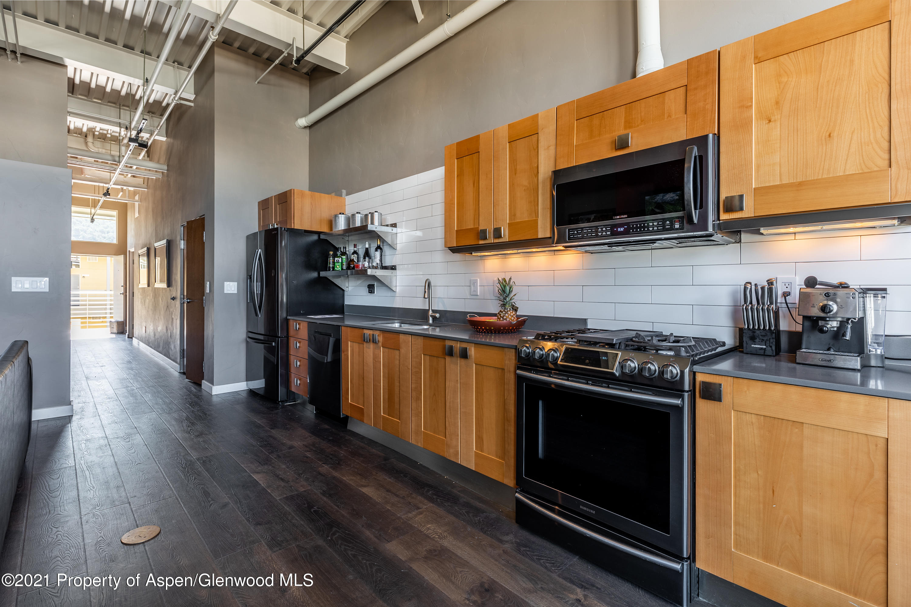 231 Robinson Street, Unit 306 Basalt, CO 81621 - Photo 12 of 15 a kitchen with stainless steel appliances a stove a microwave oven cabinets and wooden floor