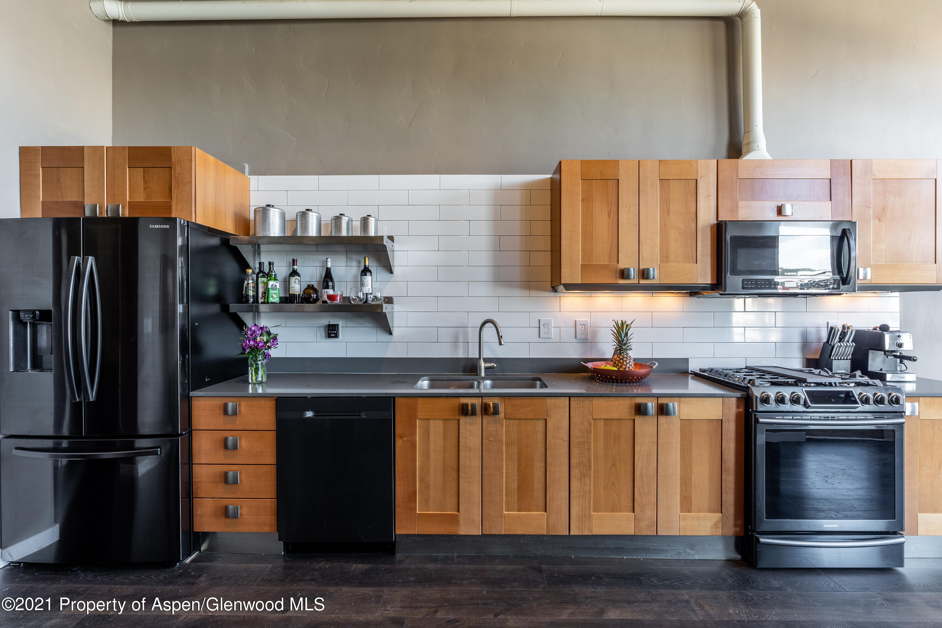 231 Robinson Street, Unit 306 Basalt, CO 81621 - Photo 2 of 15 a kitchen with stainless steel appliances wooden cabinets and a sink