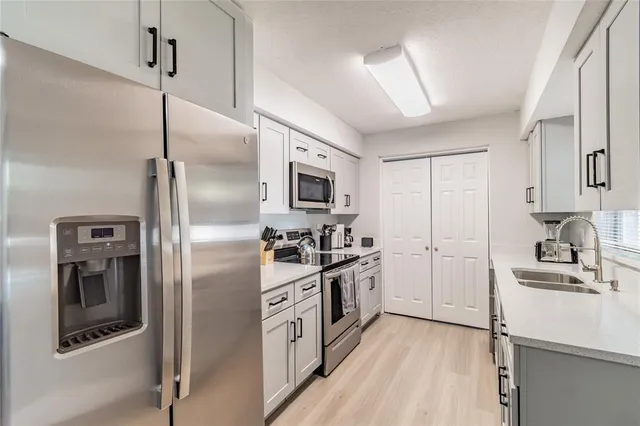 a kitchen with stainless steel appliances granite countertop a refrigerator stove and sink