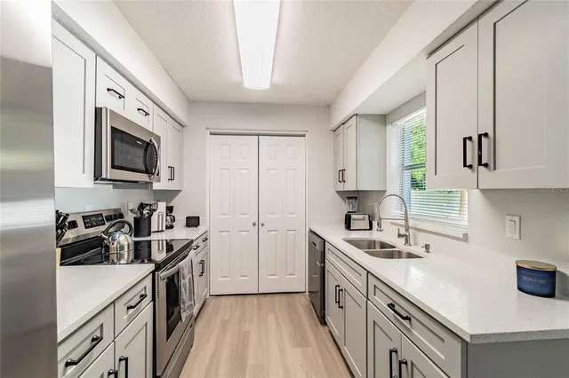 a kitchen with a sink stove top oven and cabinets